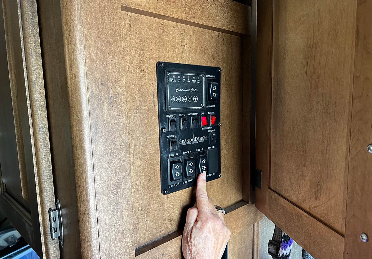 hand reaching for a control panel in an RV