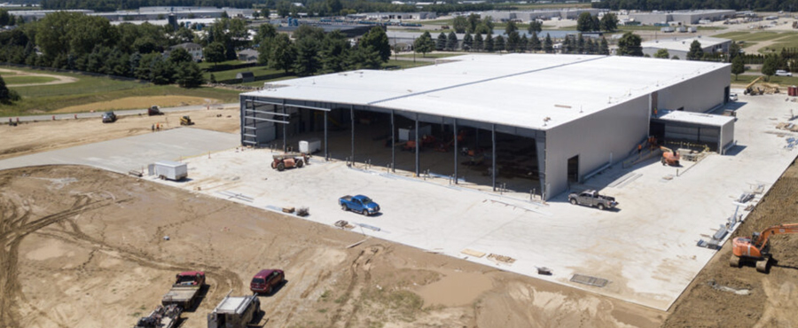 aerial view of warehouse being built in a dirt lot