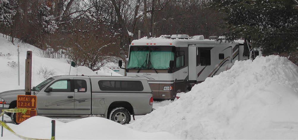 Pickup truck and RV at a snowy campground