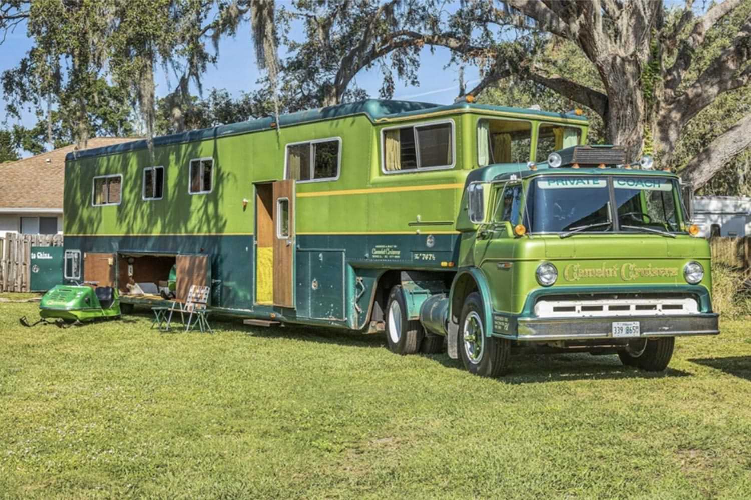 a green-on-green 1974 Ford C-750 truck and Gerstenlager trailer outfitted as a Camelot Cruiser motorhome