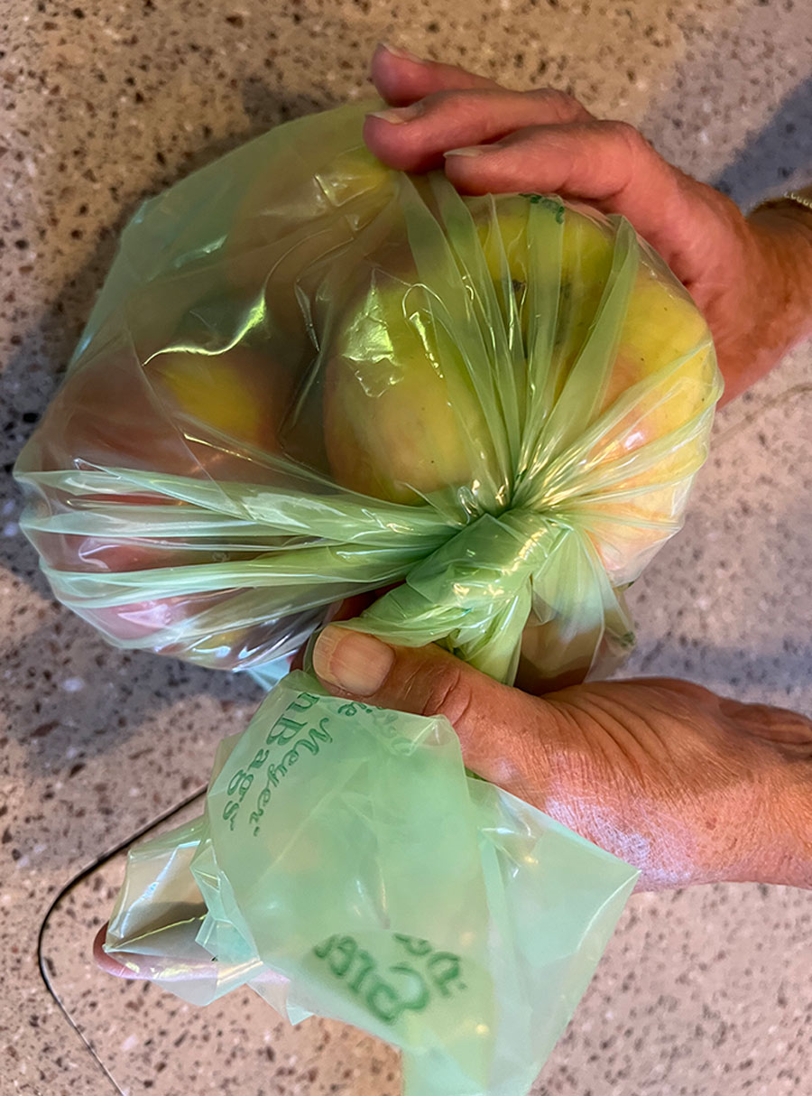 twisting the top of the bag and folding it down over to keep apples secure