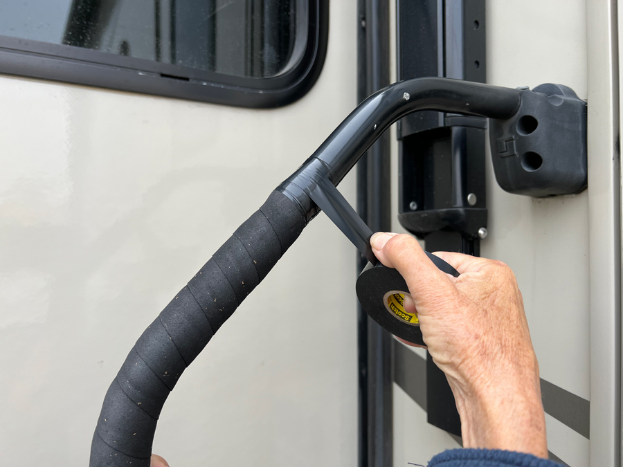 hand wrapping electrical tape around a grab handle