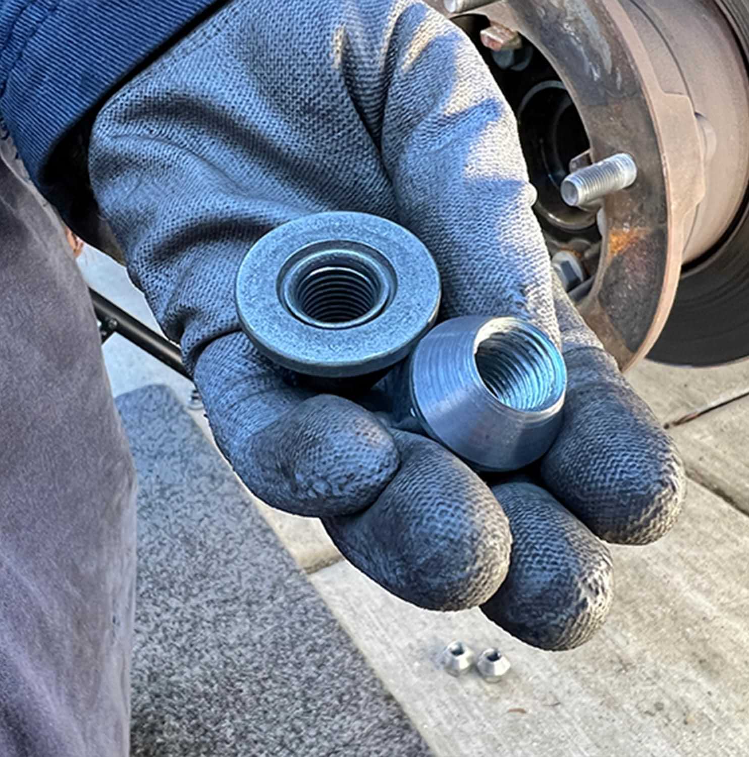 a hand holding SuperSteer WAL-nut (wheel alignment nut) components