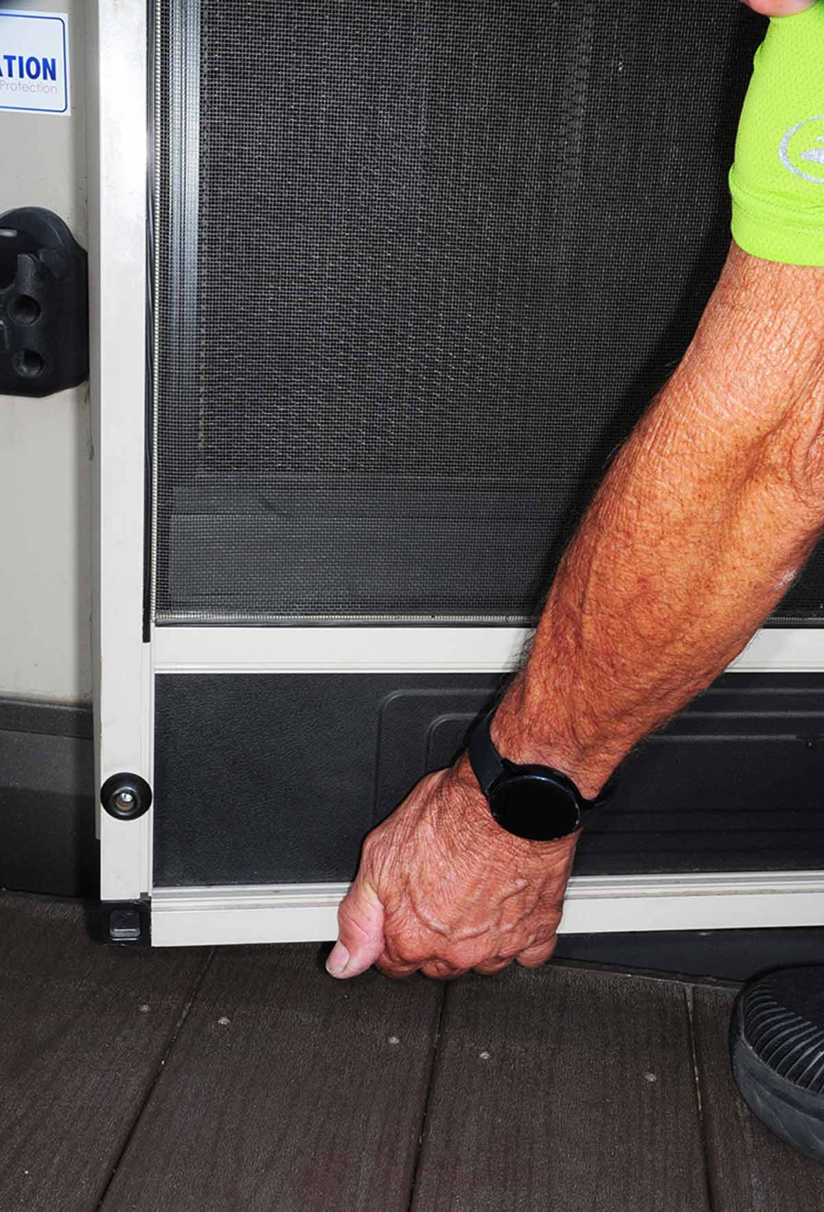 man's arm holding up screen door