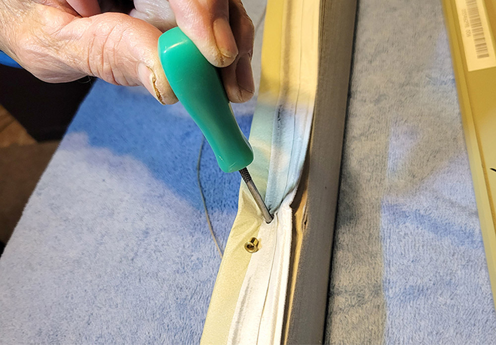 Inserting awl into cord hole 