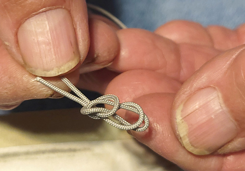Tying end of cord in a knot
