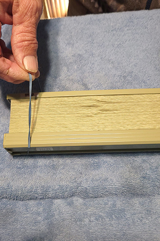 Securing collapsed blind with rubber band