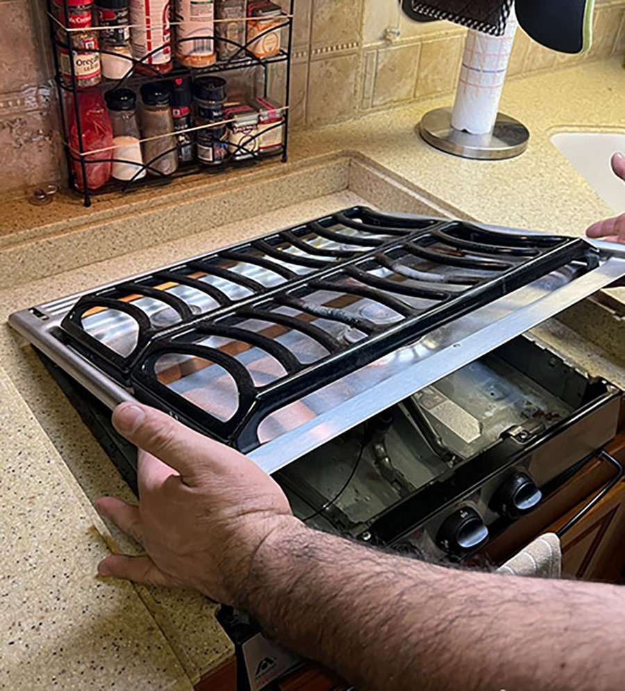 The first step is to shut off the propane at the tank. The grill assembly is then pushed backward and lifted up to remove from the base of the unit.