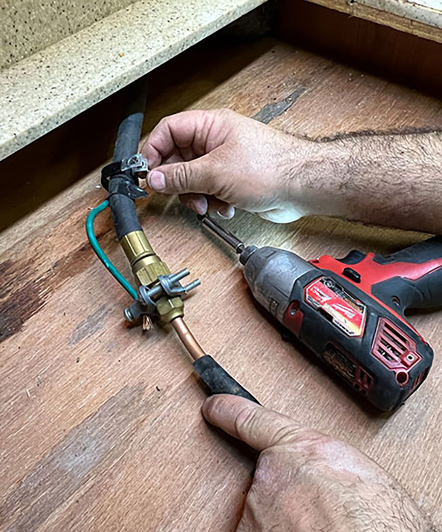In this installation, the OEM gas line was connected inside the cooktop. The line had to be repositioned because the new cooktop gas line feed is external at the rear of the unit.