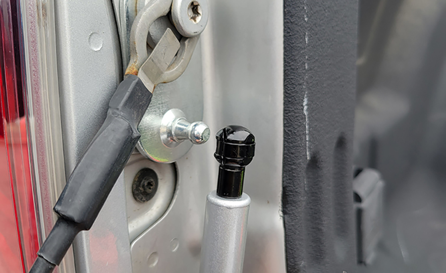 Lastly, the strut was installed on the balls attached to the brackets. The upper, thicker end, goes on first. The lower arm needed to be compressed to locate the socket on the ball. A small-blade screwdriver can be used to lift the retainers on the sockets that go over the balls should the strut need to be removed.