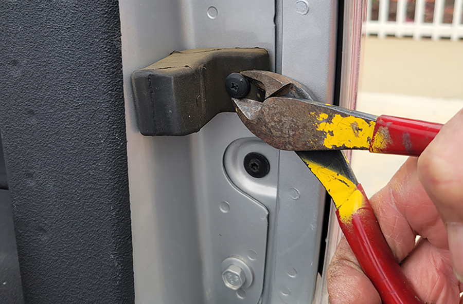 A diagonal cutter was used to cut a plastic rivet that held the rubber bumper in place. This bumper must be removed before the strut can be installed. It twisted off once the rivet was cut.