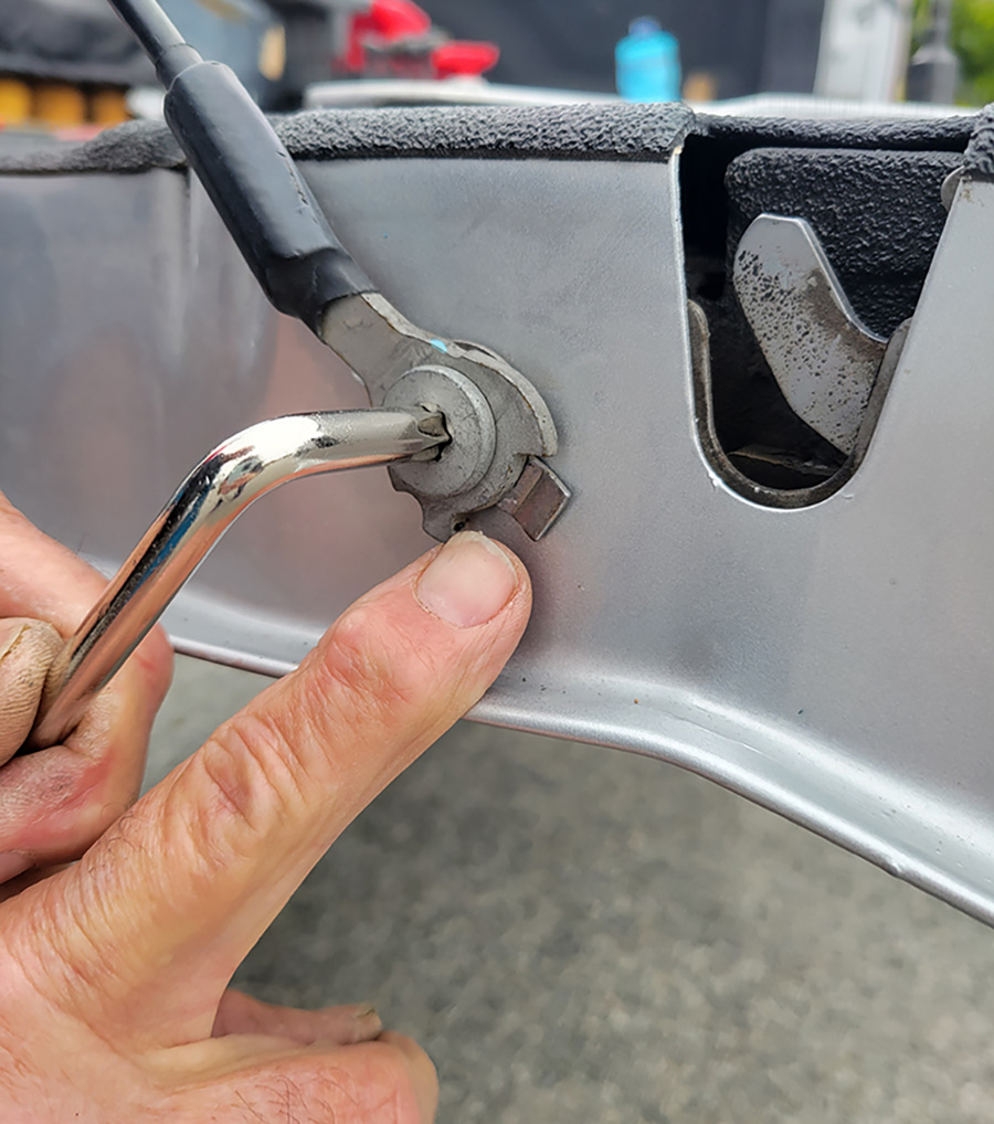 The bolt that secures the lower cable eyelet (to control the amount of tailgate travel) was removed to access the limiter plate to straighten the tabs. At first, a pliers was used to bend the tabs, but it didn’t work. Consequently, a punch and hammer (suggested in the instructions) made short work out of flattening the tabs. The limiter cannot be removed from the locking washer, so maneuvering the punch is a little tricky. Once flattened the limiter and cable end were replaced in the original position.