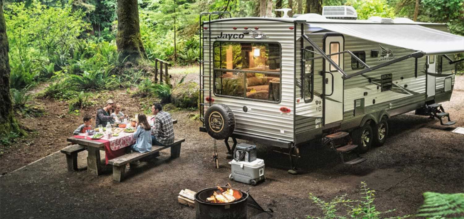 high angle view of a family enjoying a picnic in the forest near their Jayco RV
