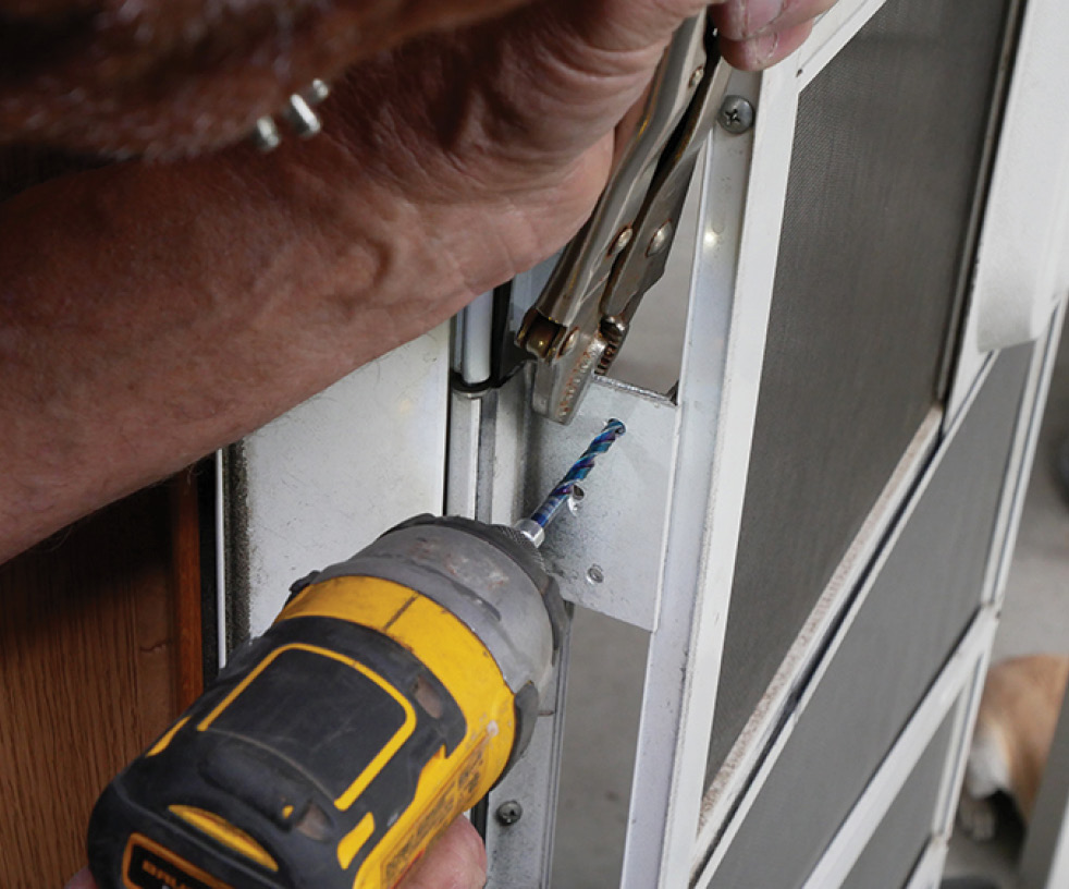 newly attached bracket being positioned against the leftover entry door hinge