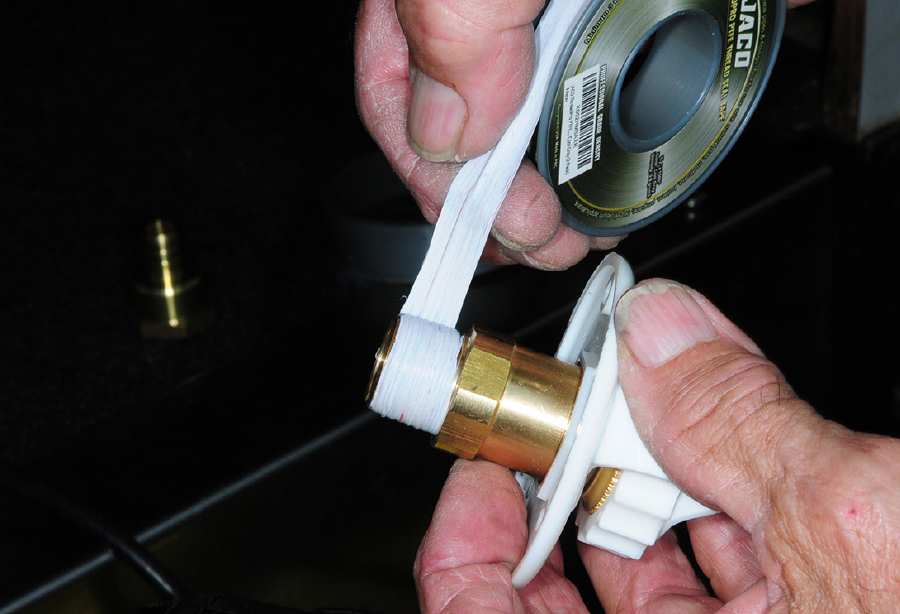 Wrapping the make pipe threads on the city water fill with Teflon tape