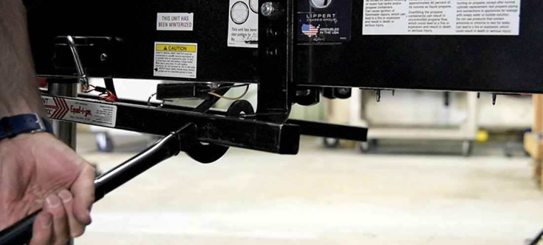 It’s best to lift the coupler and hitch head with the A-frame jack to release enough pressure to secure the spring arms on the L-brackets. At first the spring arms were somewhat difficult to swing out when pinned into the hitch head sprockets, but after a few trips, this process became easier. A provided Snap-up lever helps lift the spring arms over the L-bracket.