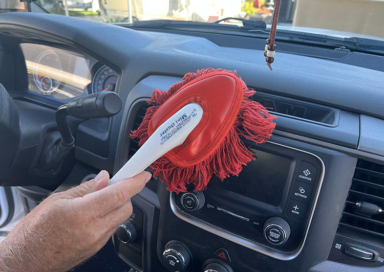 small duster dusting the dash of the truck