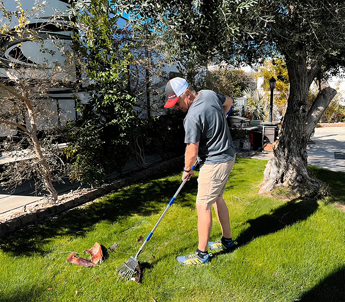 Person raking leaves on small lawn in RV park