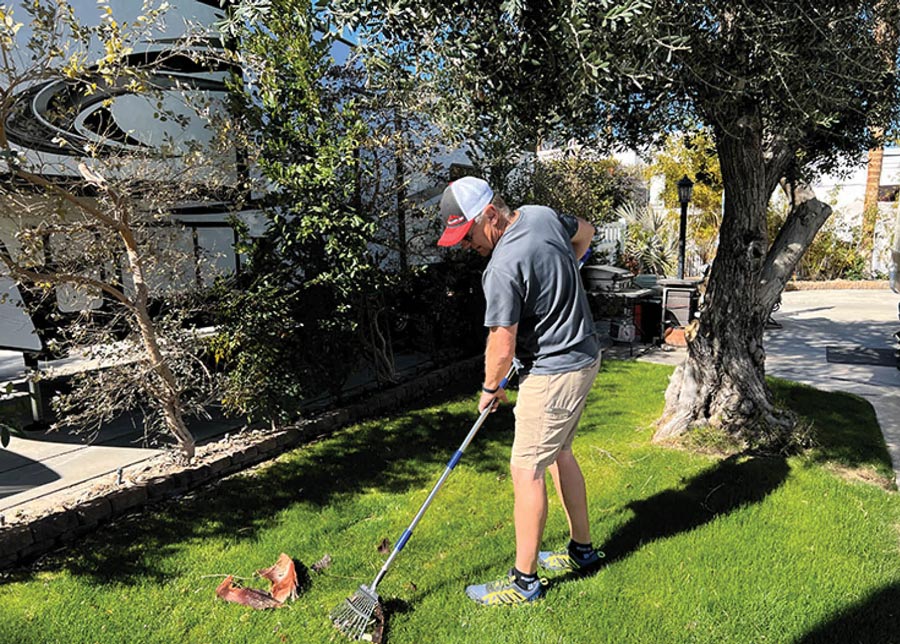 man raking up leaves