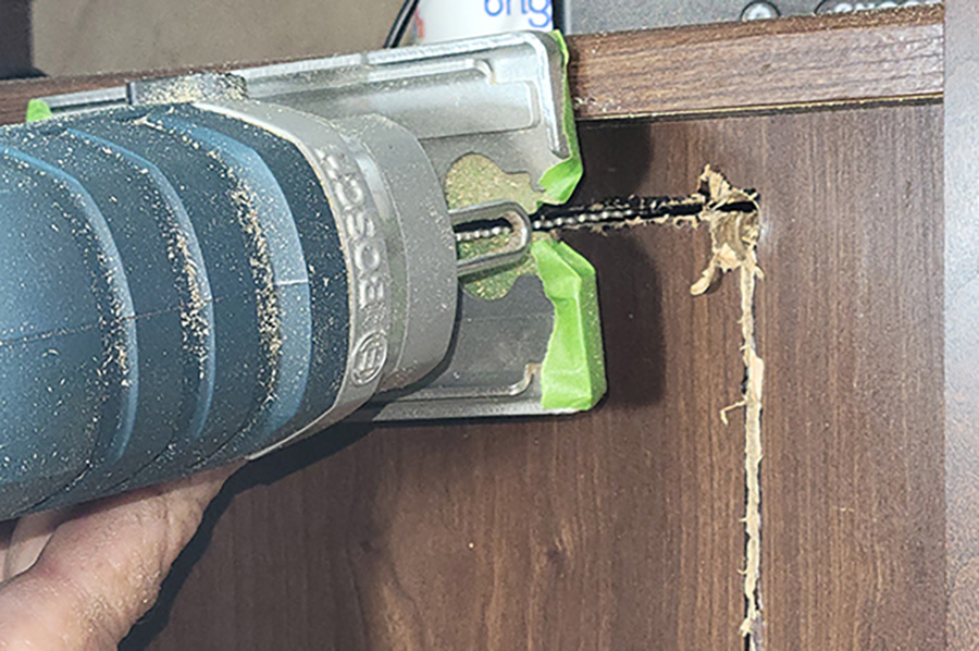 The only snag when cutting the hole was the raised perimeter that made it impossible to lay the jigsaw flat against the wood panel that held the TV. Also, it was impossible to get the jigsaw into the corner to make the final cut. A handsaw was used to cut through the last bit of wood.