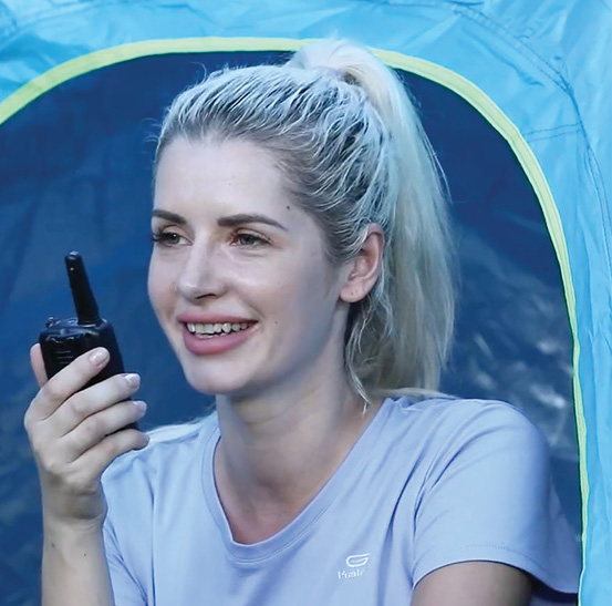 woman smiling and holding a Walkie Talkie