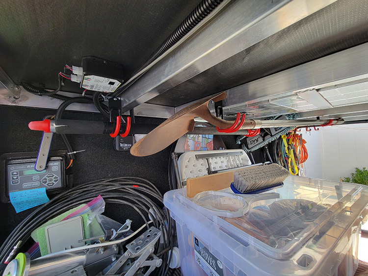 A common L-bracket, found in any hardware or home-improvement store, was first mounted to the rafter so the hook orientation would allow for a shovel and a wash-brush pole to hang side-to-side.