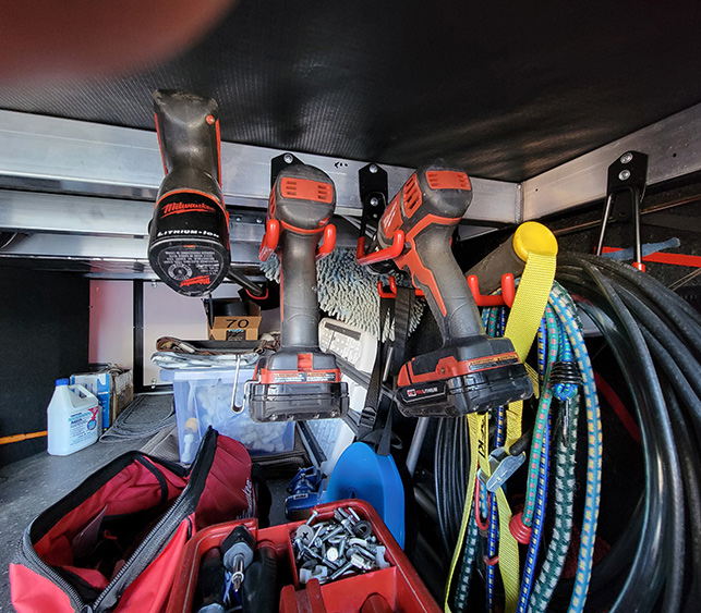 The tools were spaced so that they can be removed easily, without contortions. The rubber sleeves provide a strong hold for the tools, which is especially needed when on the road. Some of the hooks were used to hang cables, rope, bungee cords and anything else that needed to get off the floor. Now there’s plenty of room to stack things on the floor that are not used as often.