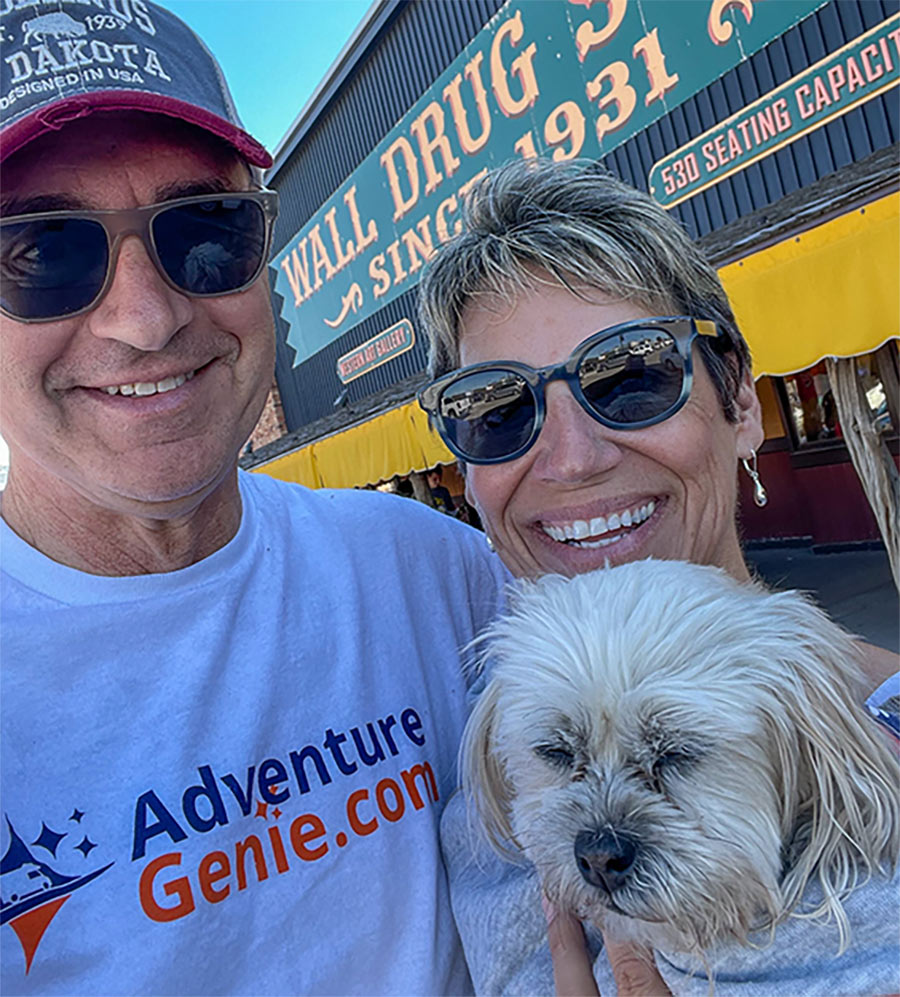 Selfie photograph of Scott and Lisa Lengel smiling and posing with Chloe, their Shih Poo dog outside Wall Drug Store in Wall, South Dakota