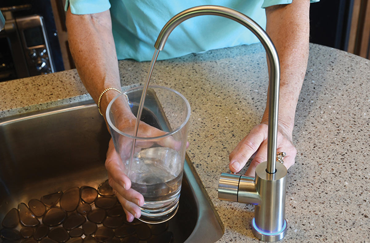 Person filling cup from tap