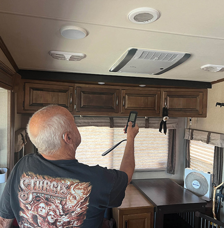 man using a remote to turn on the AC unit in his RV