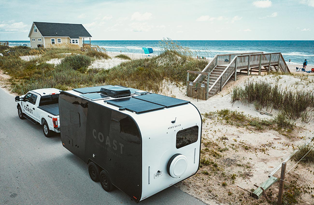 the Coast 1 trailer hitched to a heavy duty white truck and parked on a beach road