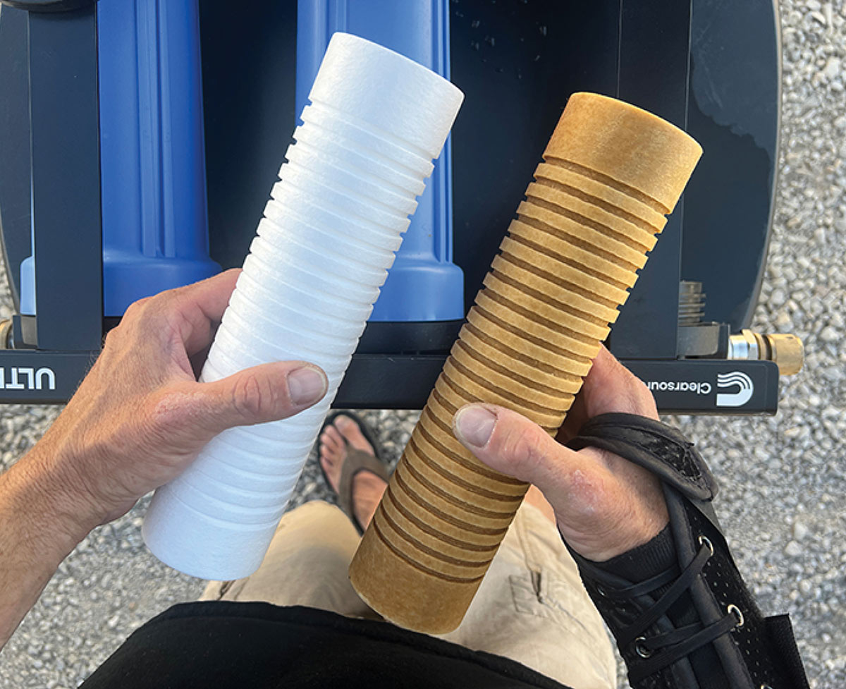 Person holding a new sediment filter next to dirty used one