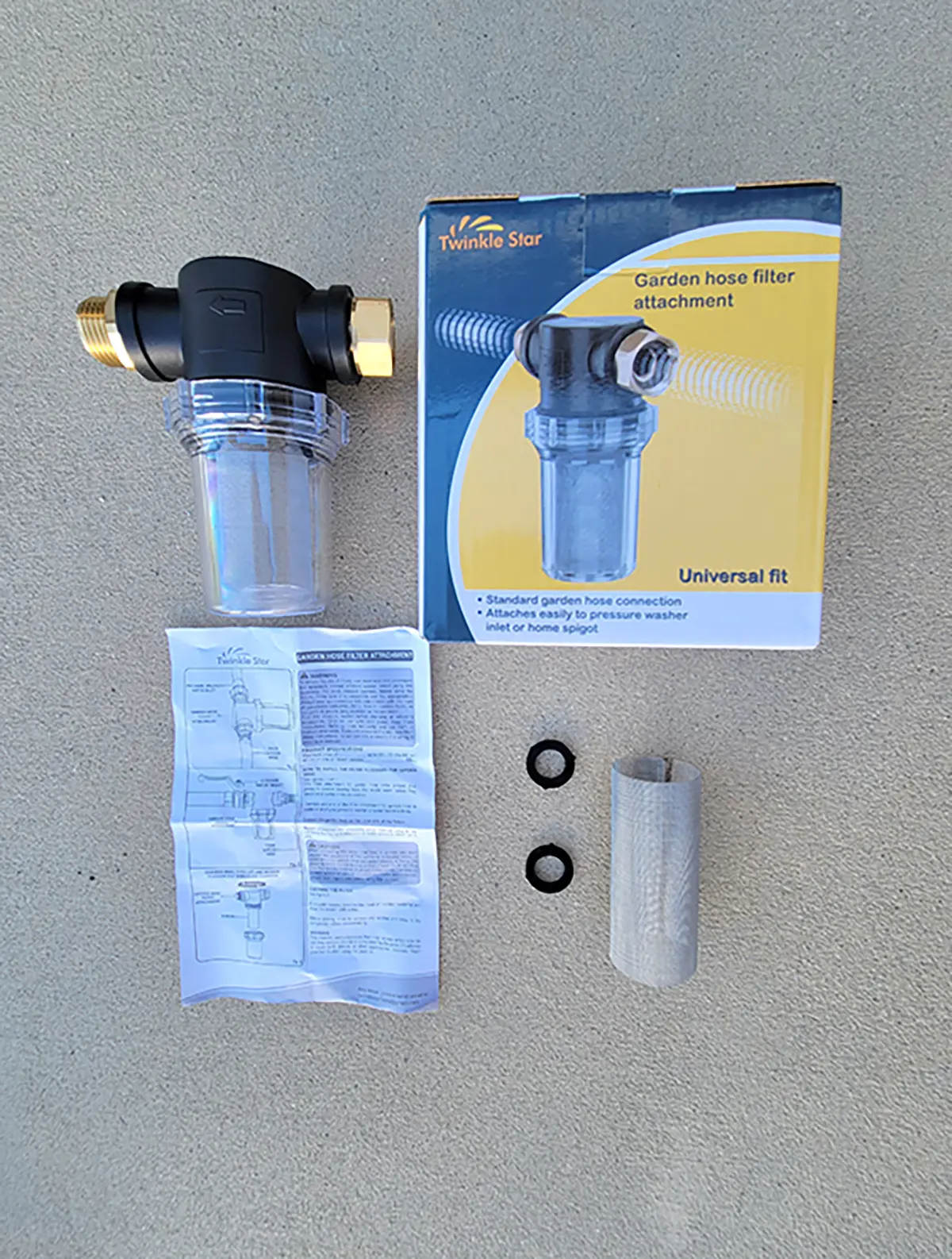 Close-up photograph perspective of The Twinkle Star Garden Hose Filter Attachment product with a tiny manual document, product box, and other accessories; While found on Amazon for $16.99, it was originally targeted as a filter for pressure washers that are attached to a water hose. It was adapted for use as a prefilter for RV water sources.