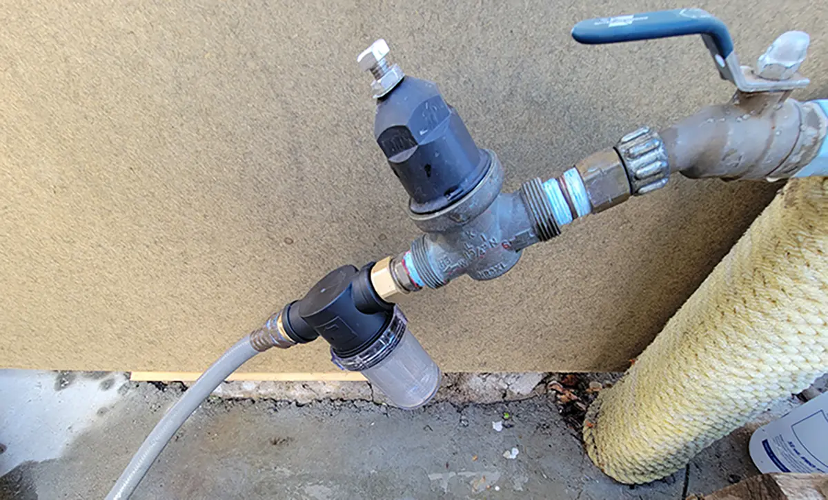 Close-up photograph perspective of the installation site of the mesh filter at the hose bib area; It was the best place right after the water pressure regulator. That way water pressure can be maintained at 50 psi; the mesh attachment is rated for 80 psi; some RV park water can exceed that pressure without a regulator.