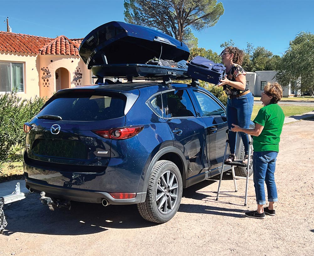 people installing a roof rack on a car