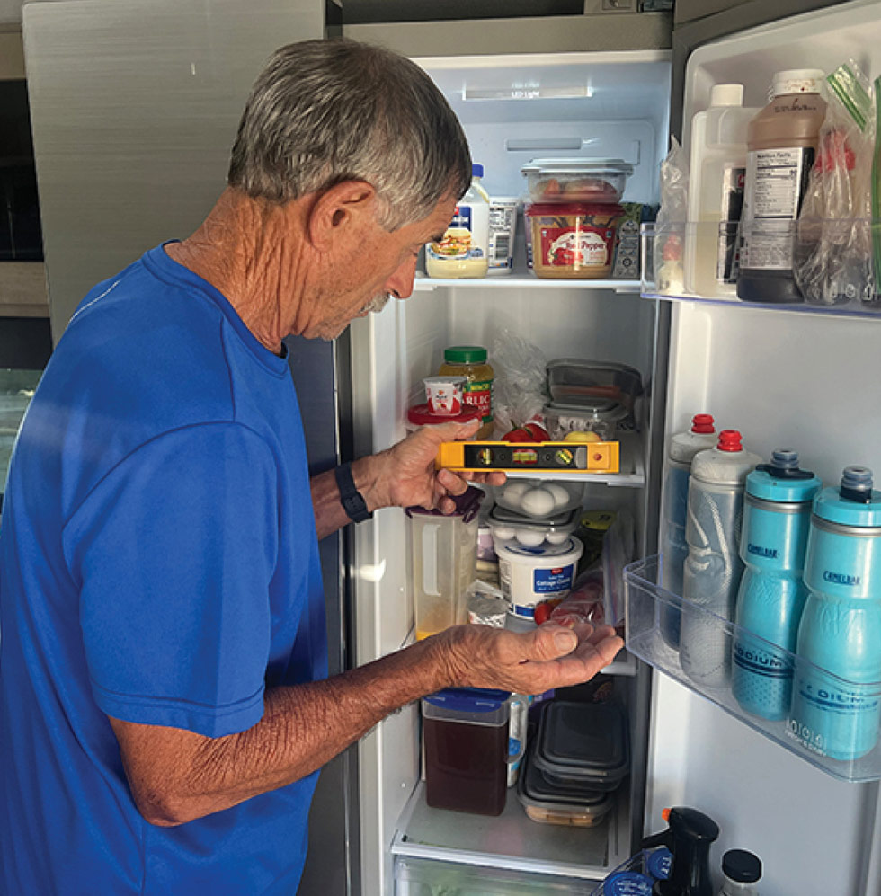 man using a level in a fridge