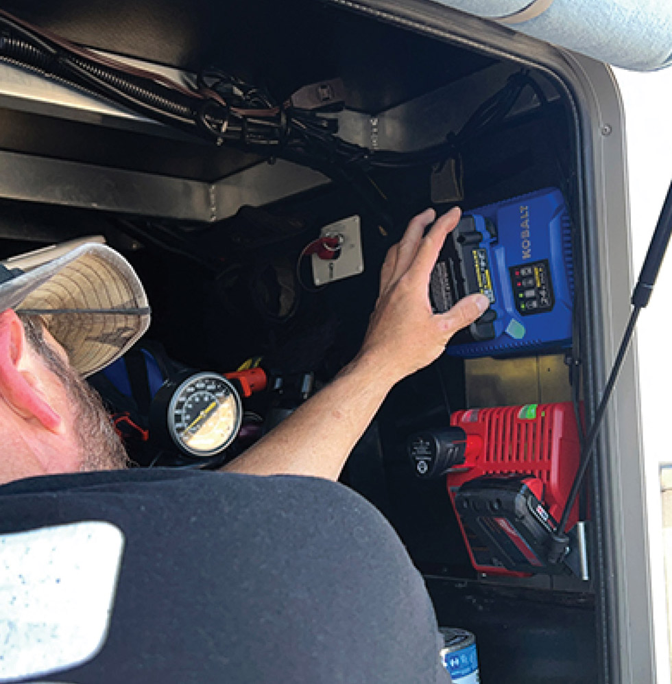 man installing a battery in an RV