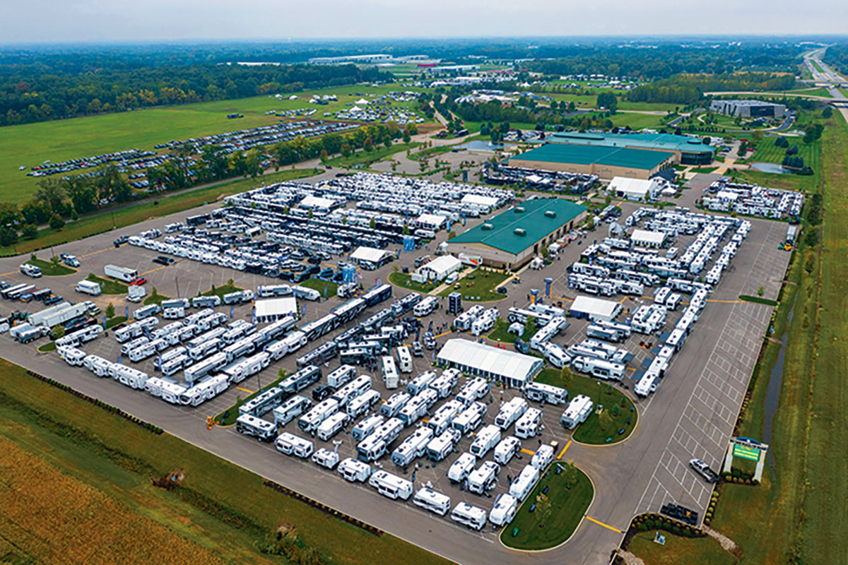 Arial view of a parking lot with a lot of RVs parked in it and a big building in the middle