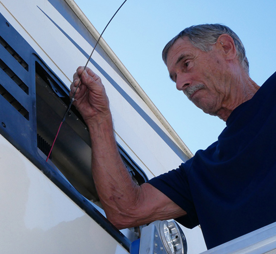 Two wires being threaded carefully around the cooling unit obstructions