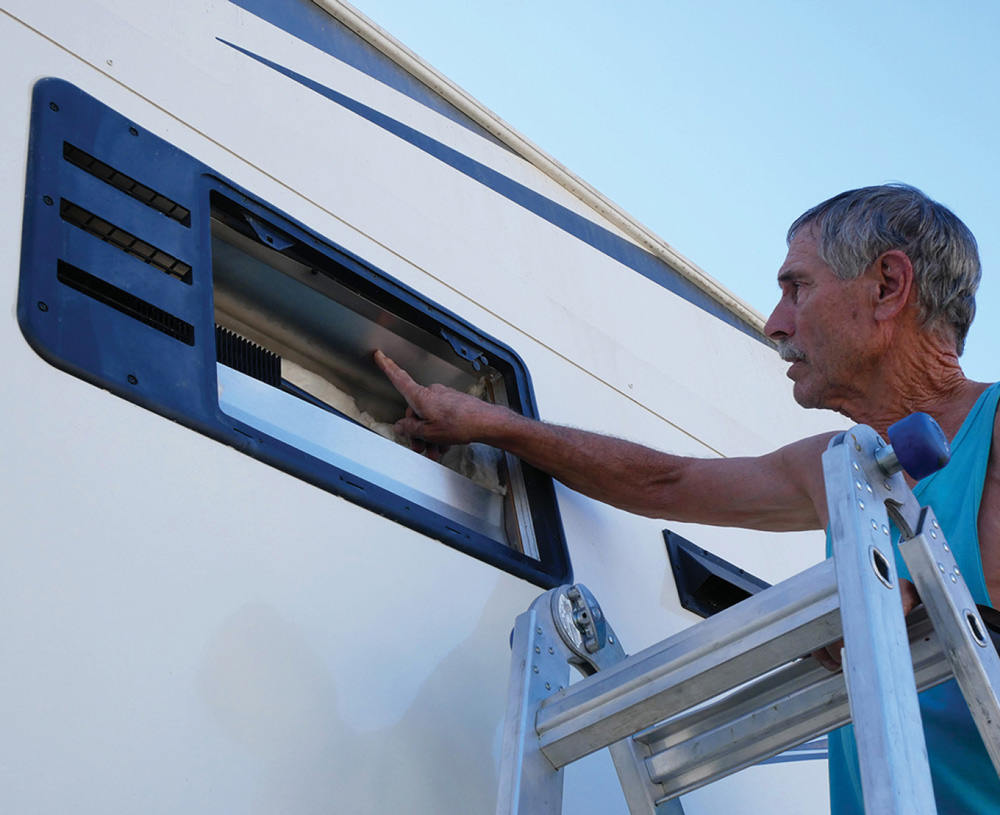 man opening a window in his RV