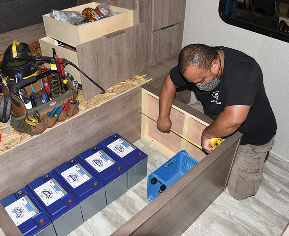 man working on battery storage for an RV