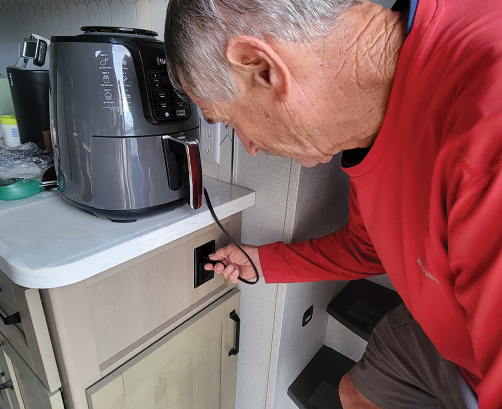 man plugging in an air fryer