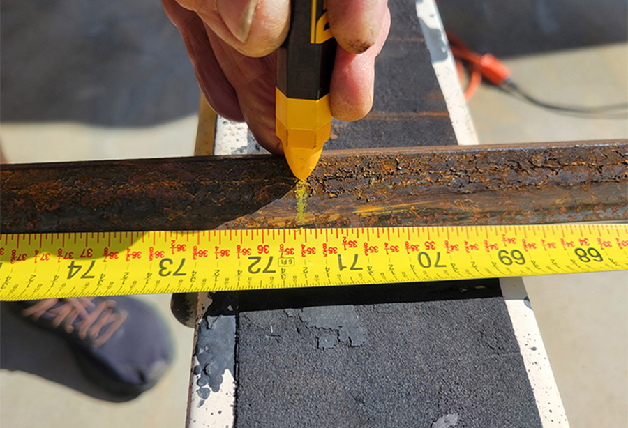 iron rod being marked with a yellow construction crayon
