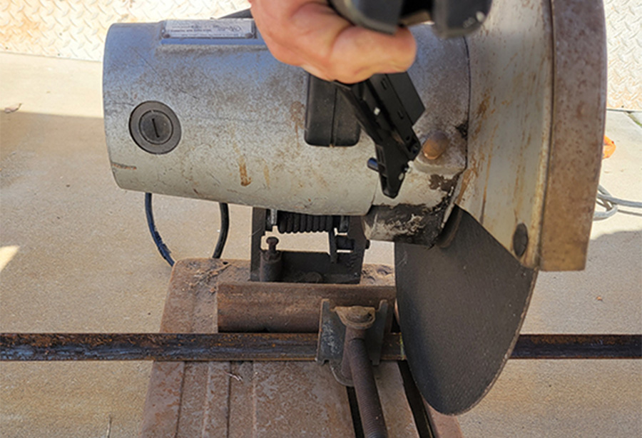 closeup of chop saw cutting through iron rod