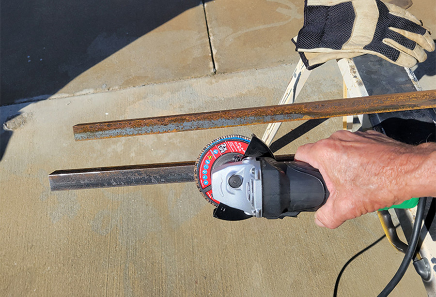 iron rod resting on a sheet of plywood with hand holding a circular hand saw