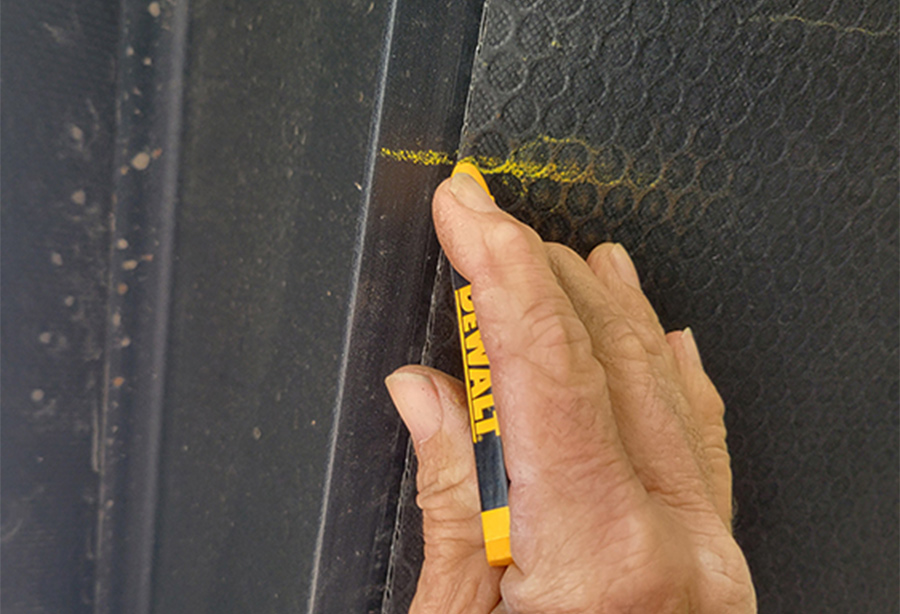 corrugated plastic being marked with a yellow construction crayon