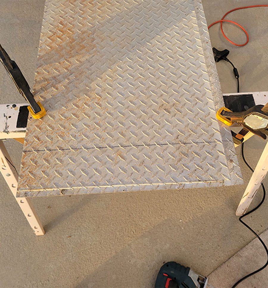 marked diamond plate clamped to sawhorses