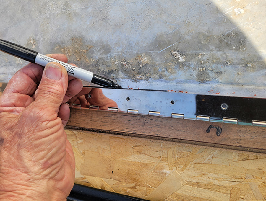 permanent marker being used to mark the location for attaching the hinge to the diamond plate