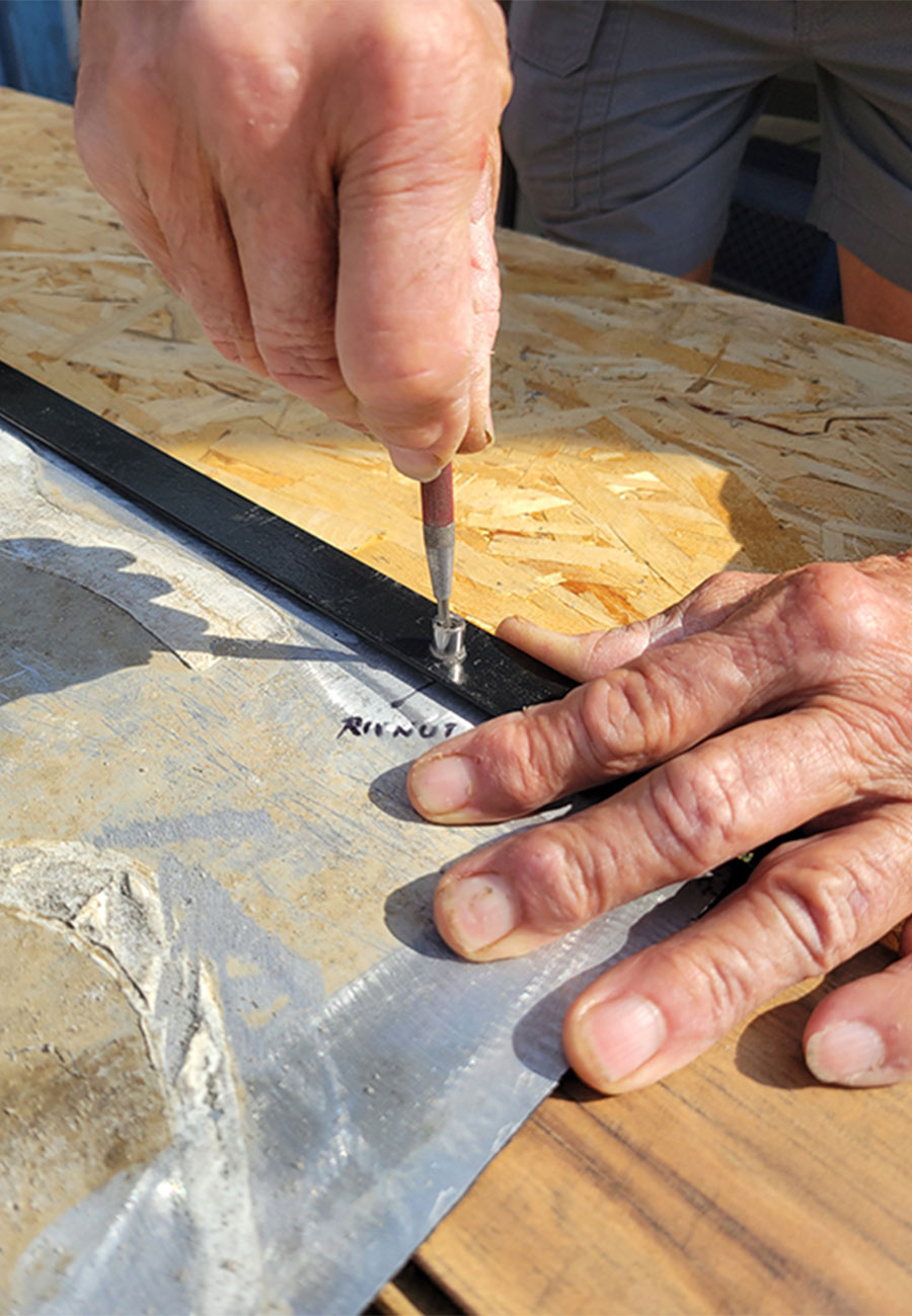 center punch being used to mark the locations for lining up the edges of the diamond plate with the rivet nuts