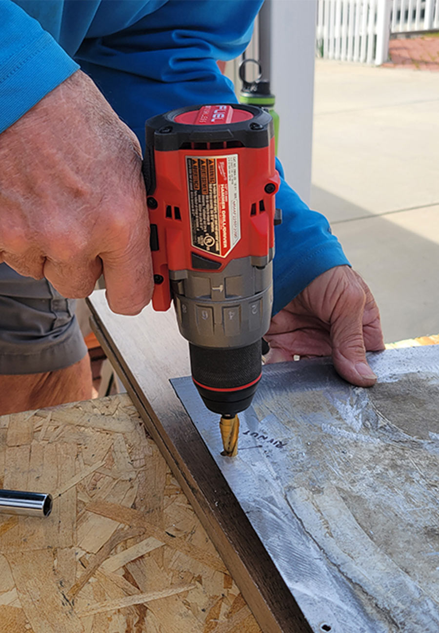 drill being used to create holes on a a diamond plate